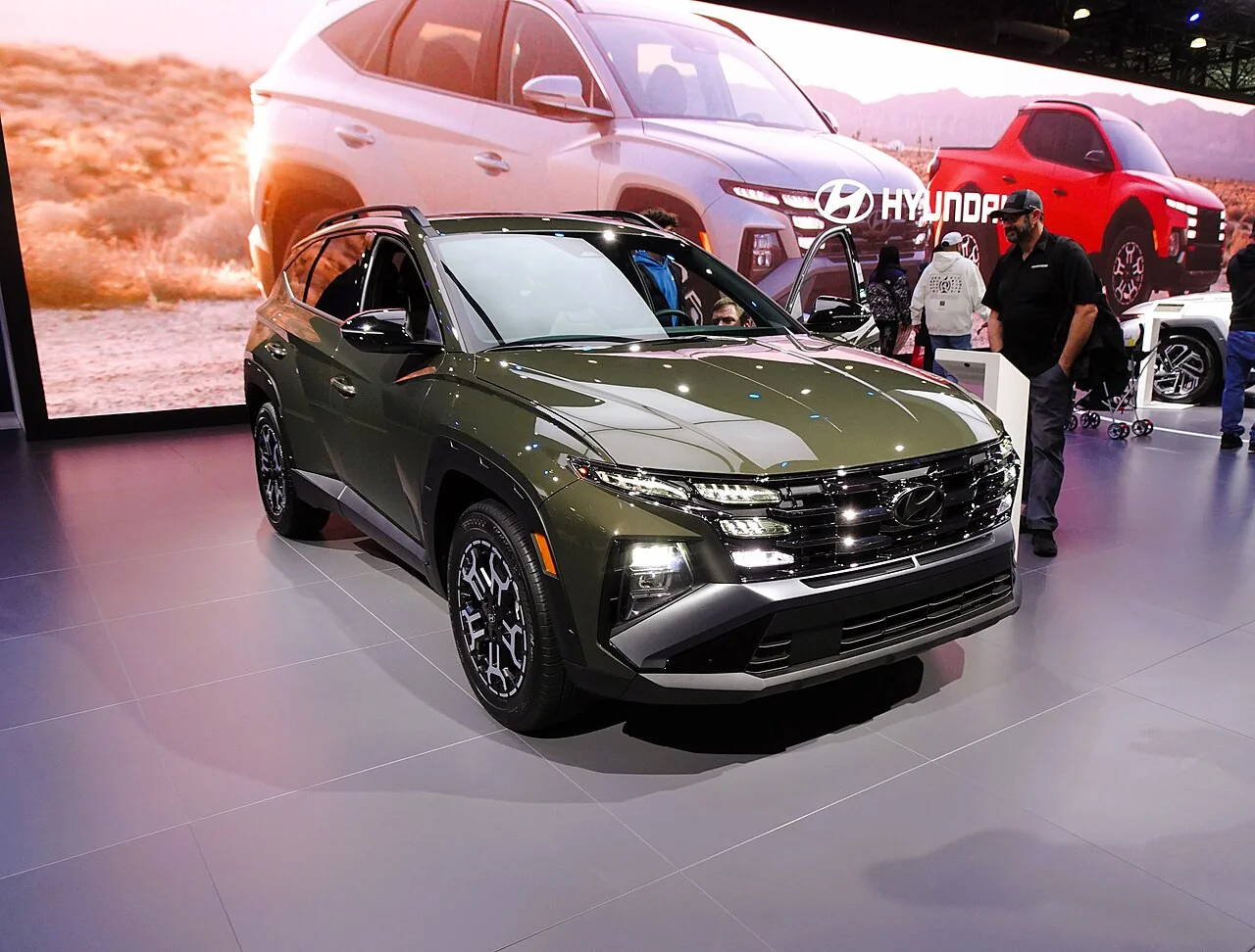Green Hyundai Tucson XRT on display at an auto show, front three-quarter view