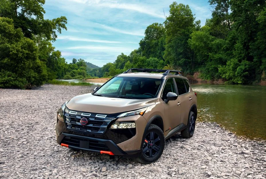 Tan Nissan Rogue Rock Creek parked on a gravel riverbank