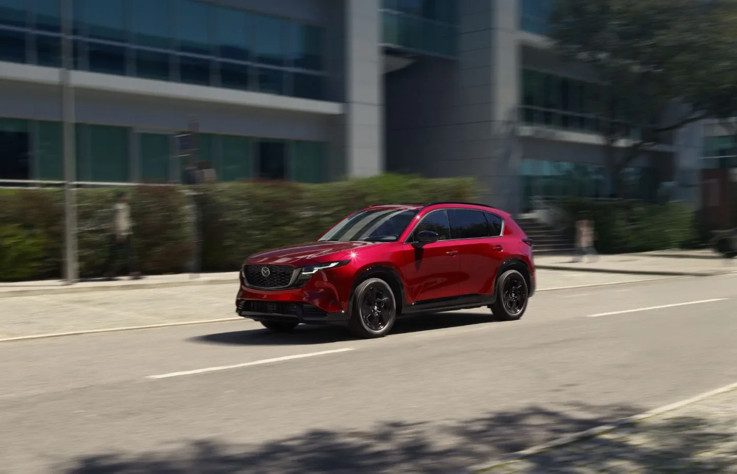 Red Mazda CX-5 driving on a city street