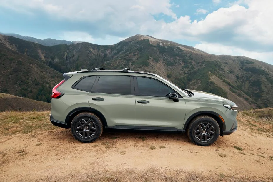Green Honda CR-V TrailSport Hybrid parked on a hillside, side view
