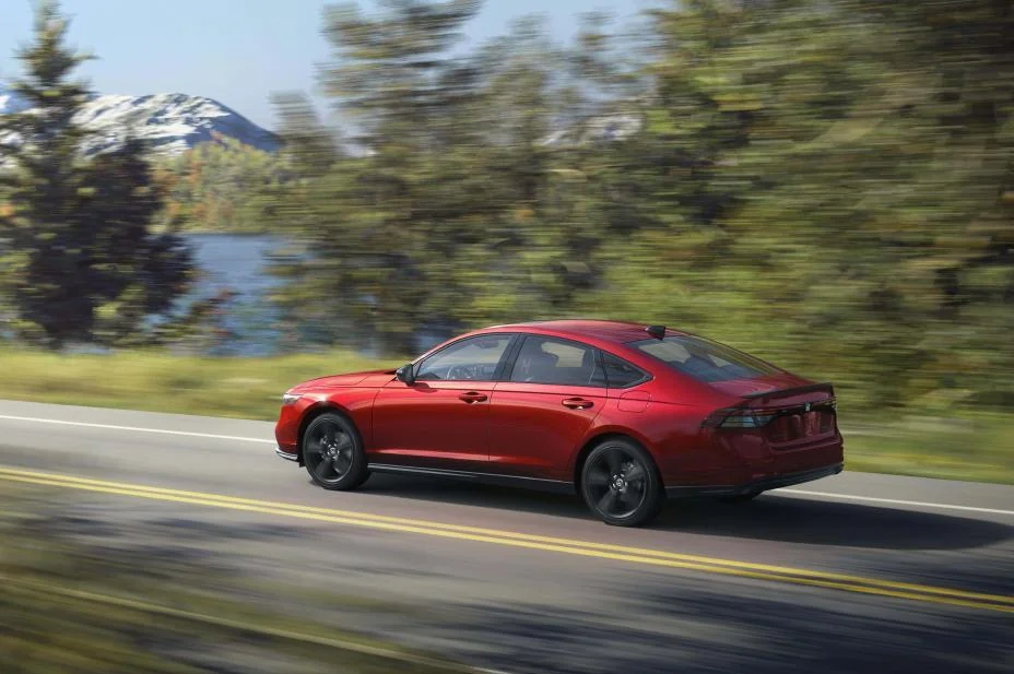 Red 2026 Honda Accord Sport-L Hybrid driving on a lakeside road